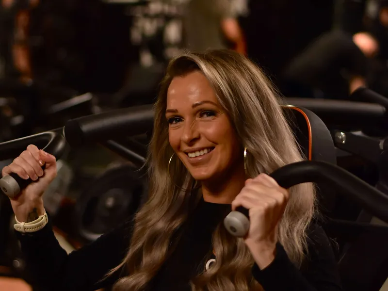 Lachende sporter traint op een krachtapparaat bij ClubFit
