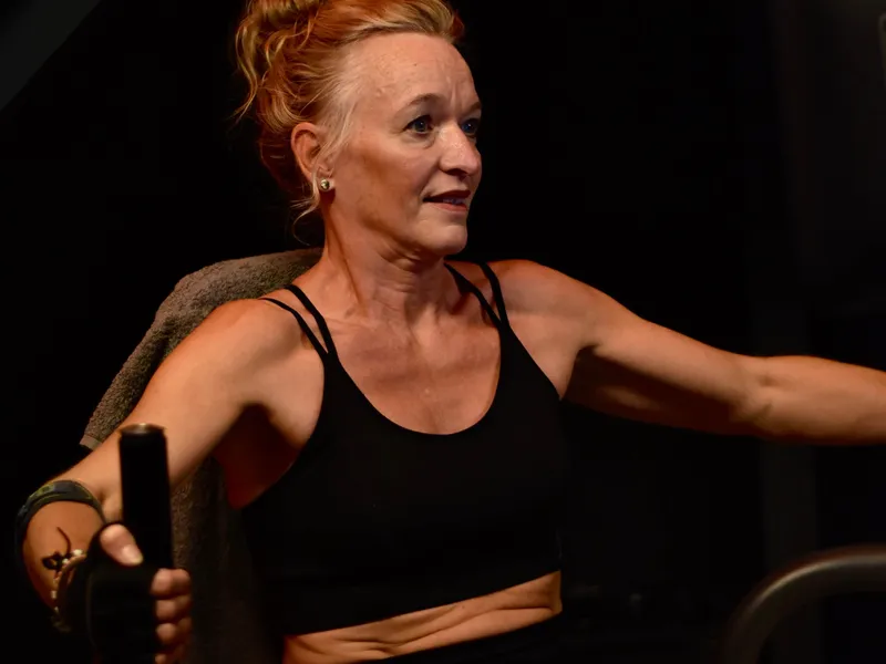 Lid van ClubFit traint geconcentreerd op een krachtapparaat